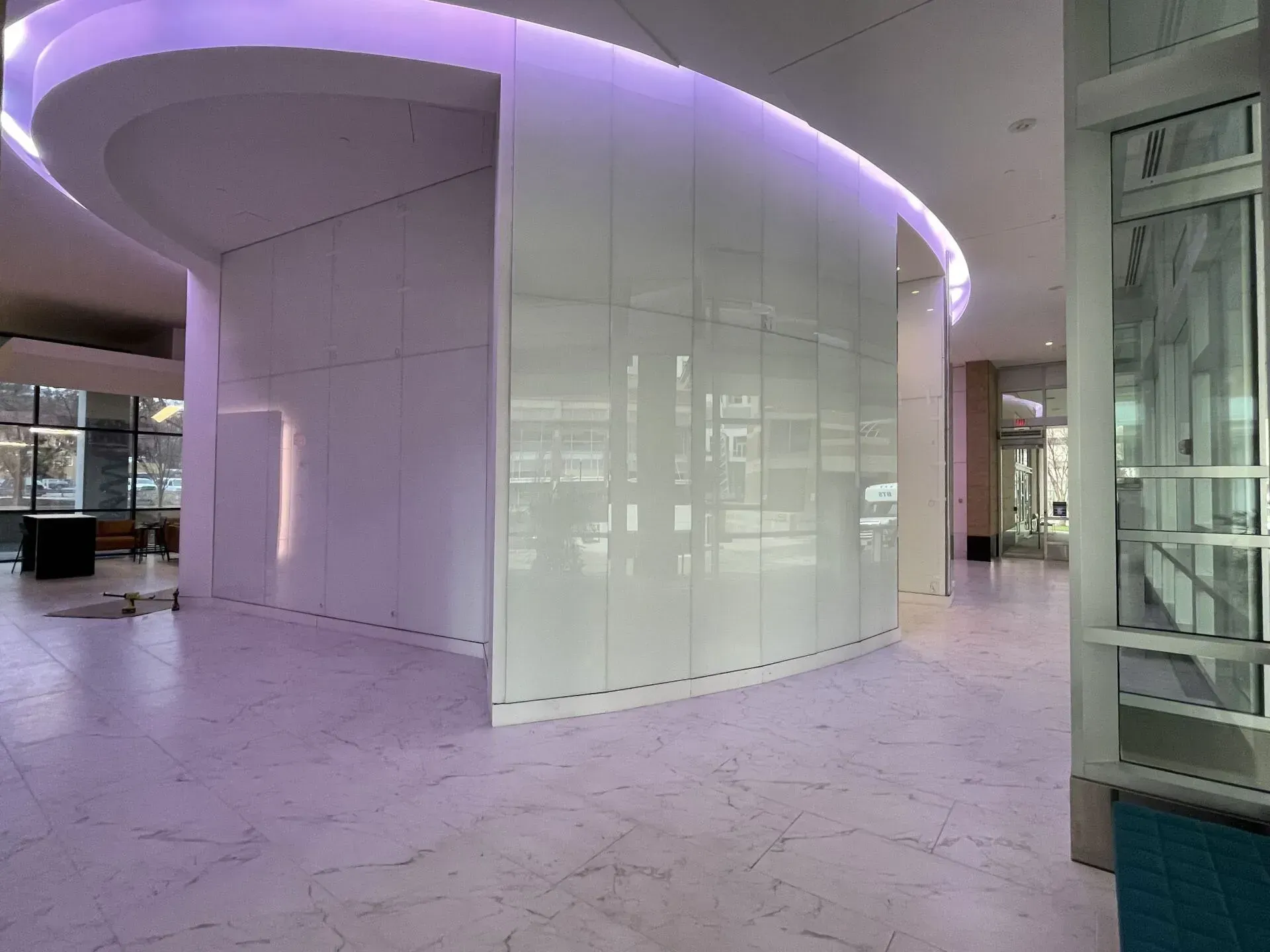 A large room with a curved wall and purple lights.