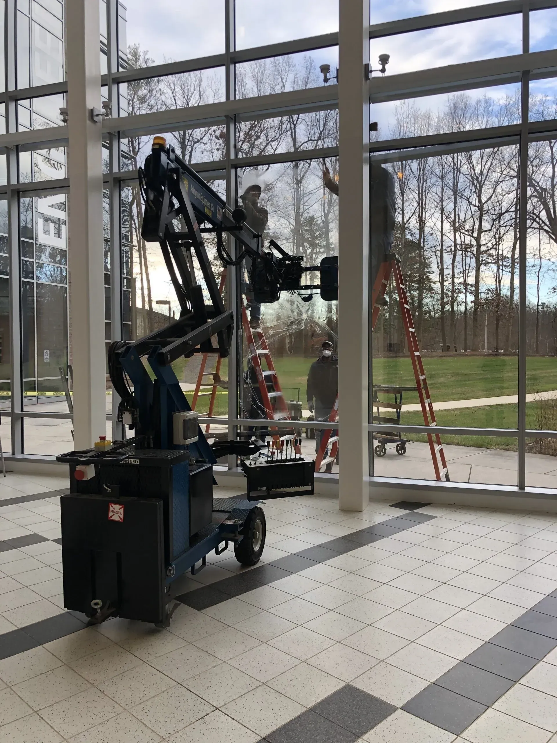 A crane is sitting in front of a large window in a building.