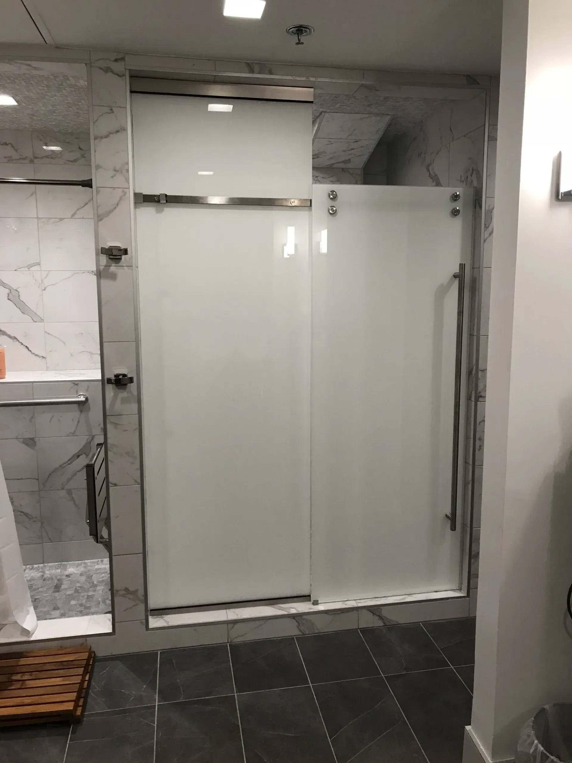 A bathroom with a sliding glass shower door