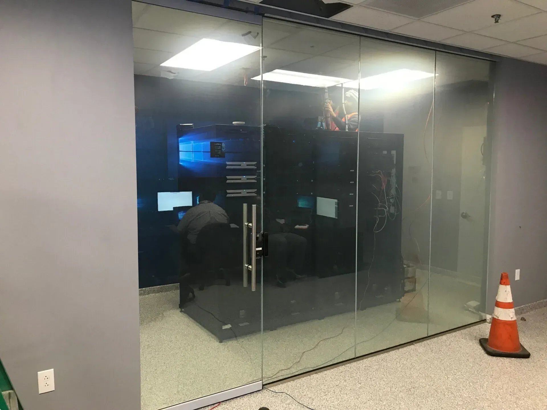 A man is standing in a room with sliding glass doors.