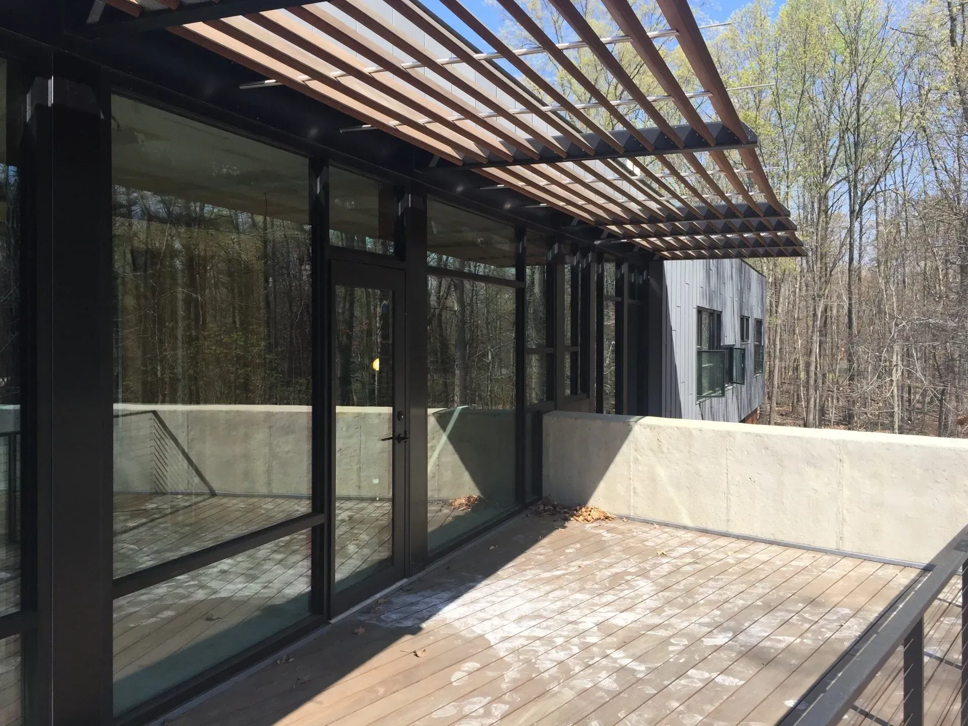 There is a wooden deck with a pergola over it.