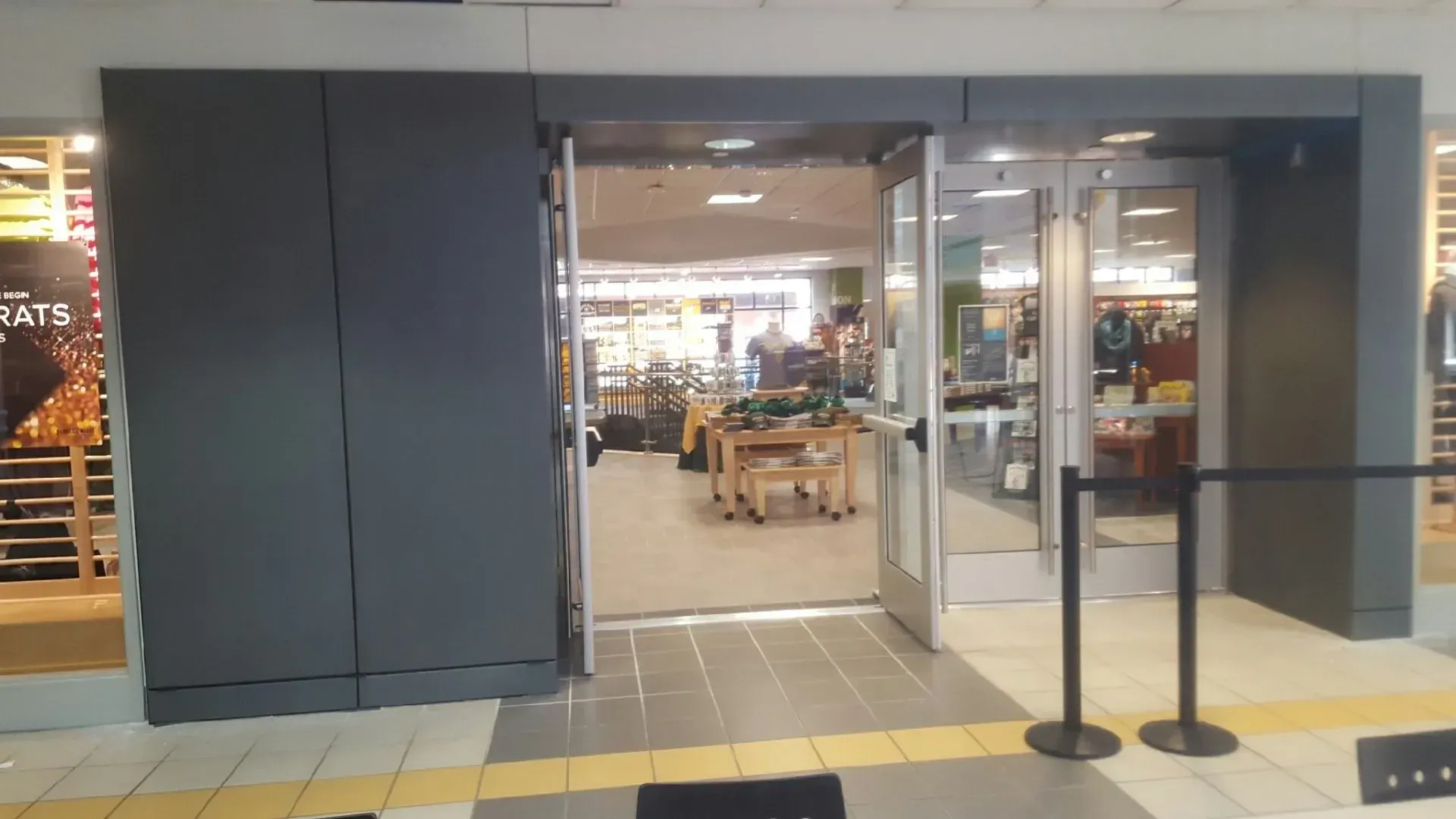A store with a sliding glass door and a black pole in front of it.