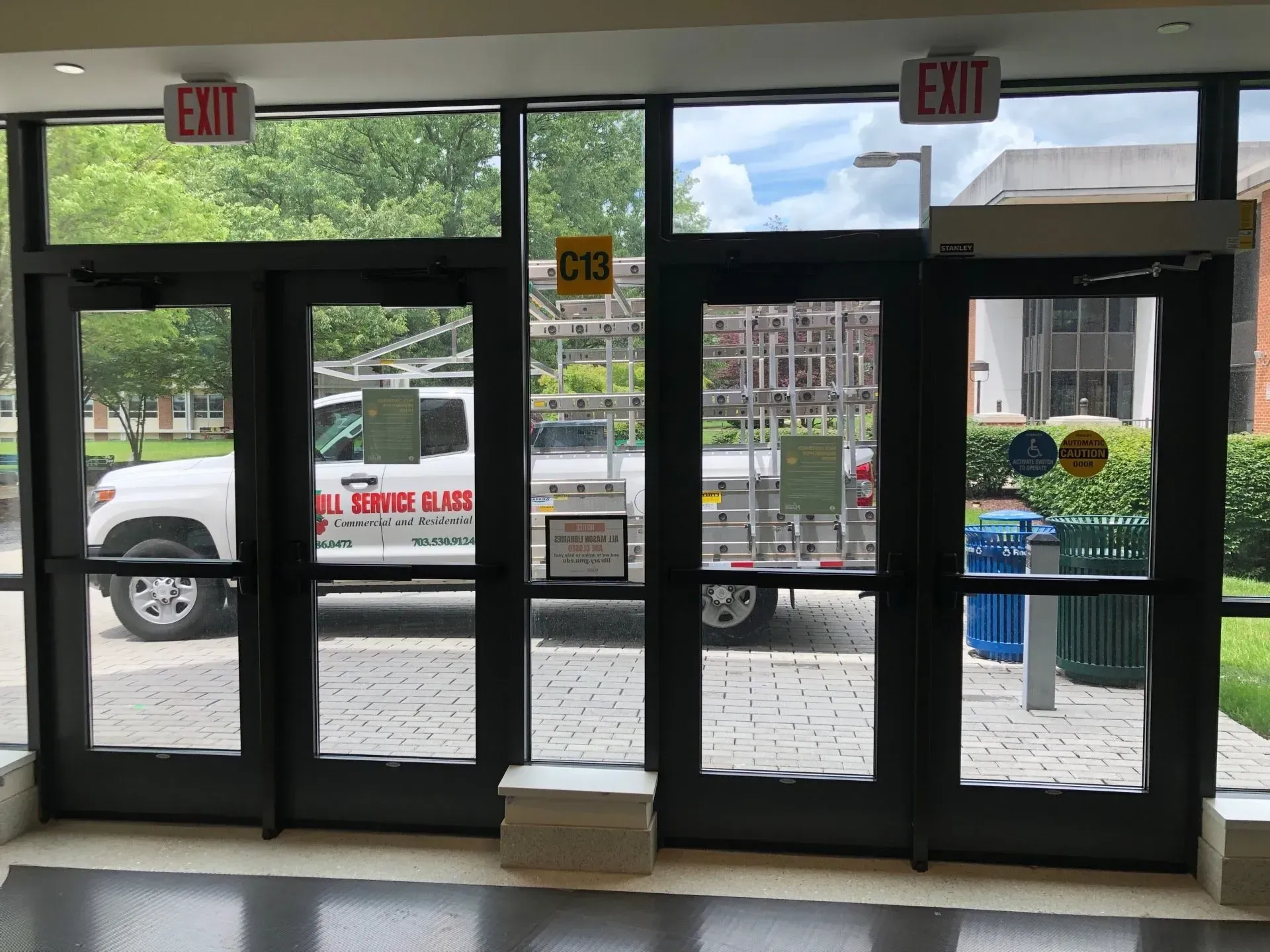 A white truck is parked in front of a building with a sign that says exit.