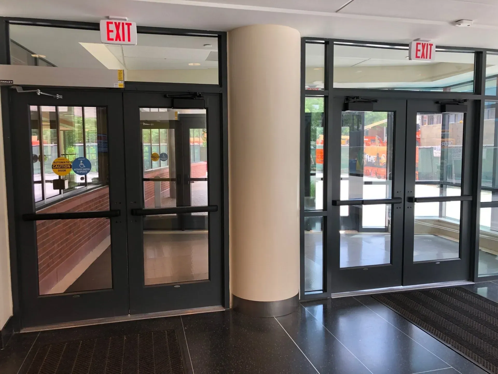 A hallway with a red exit sign on the door