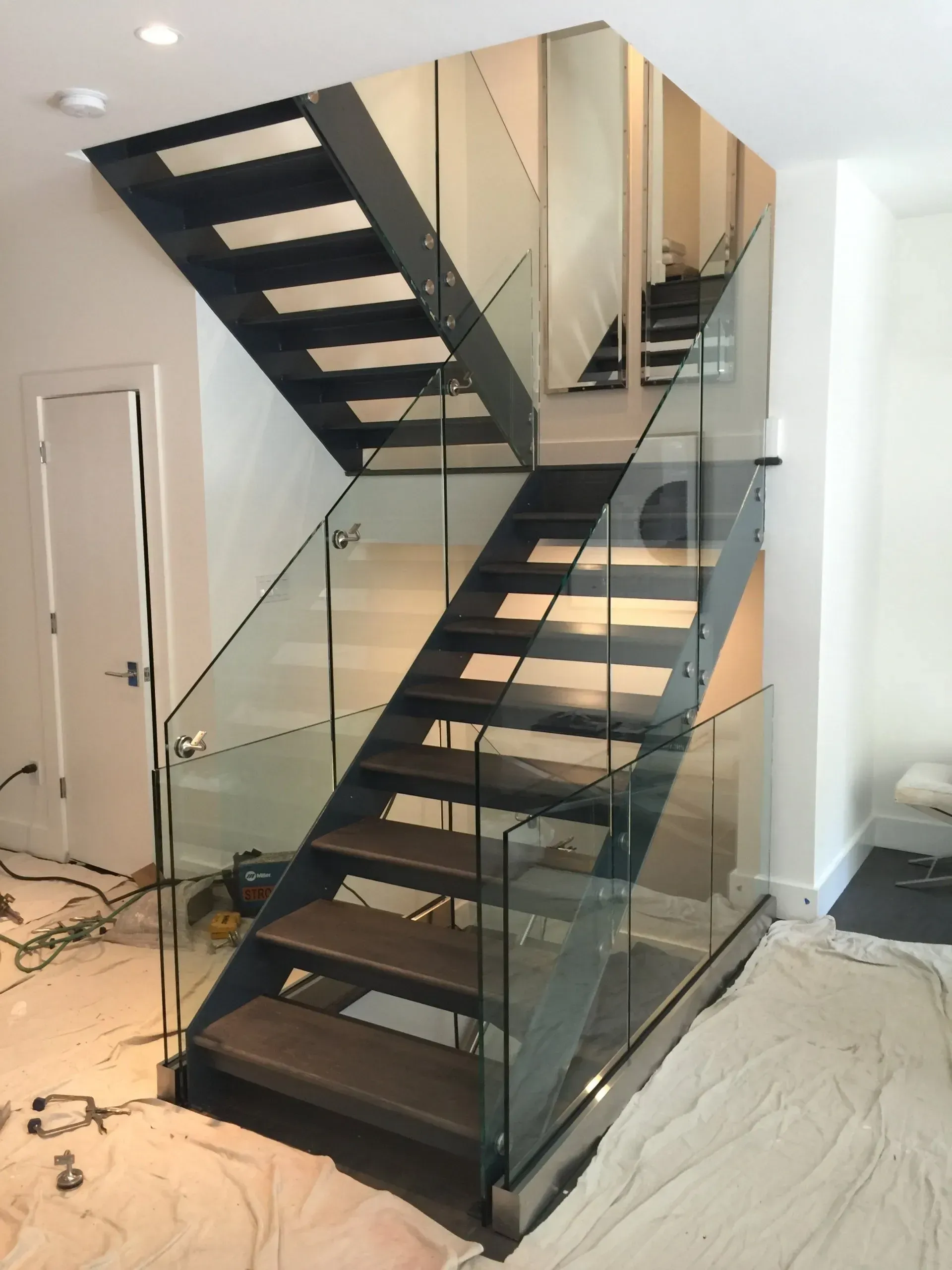 A staircase with a glass railing in a room