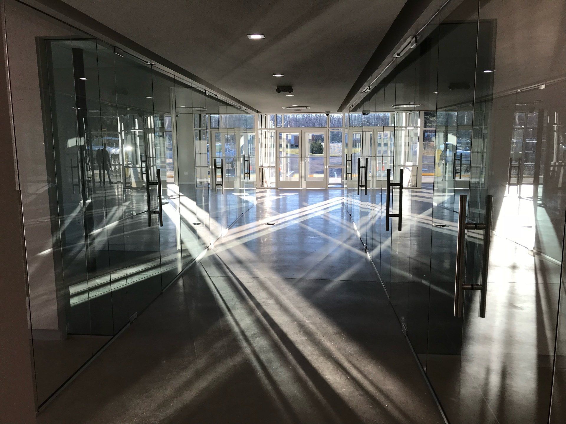 The sun is shining through the glass doors of a building.