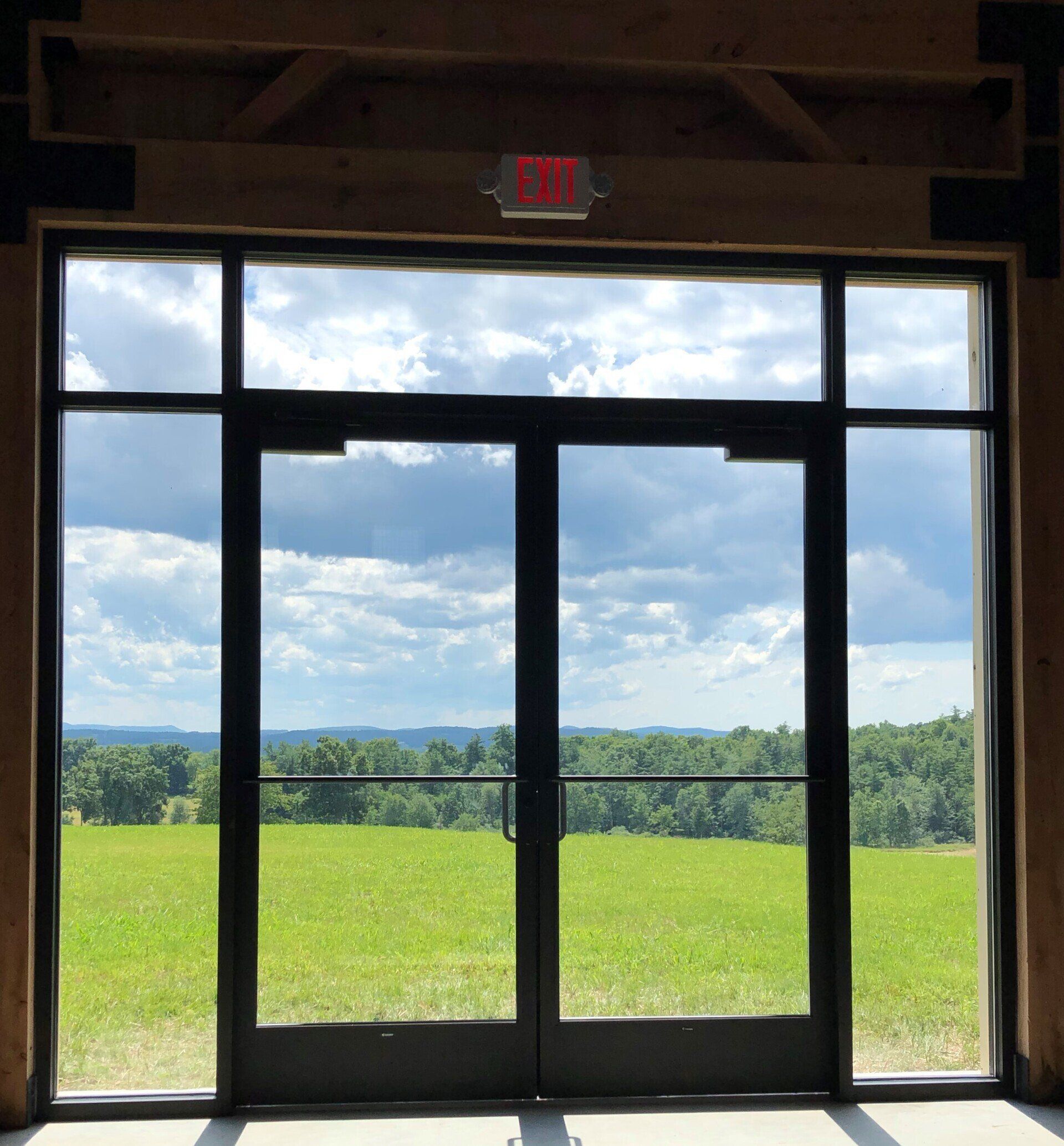 A large window with a red exit sign above it