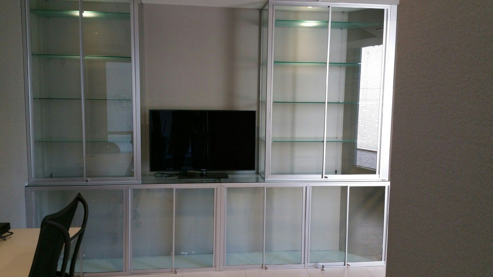 A tv is sitting on top of a glass shelf in a room.