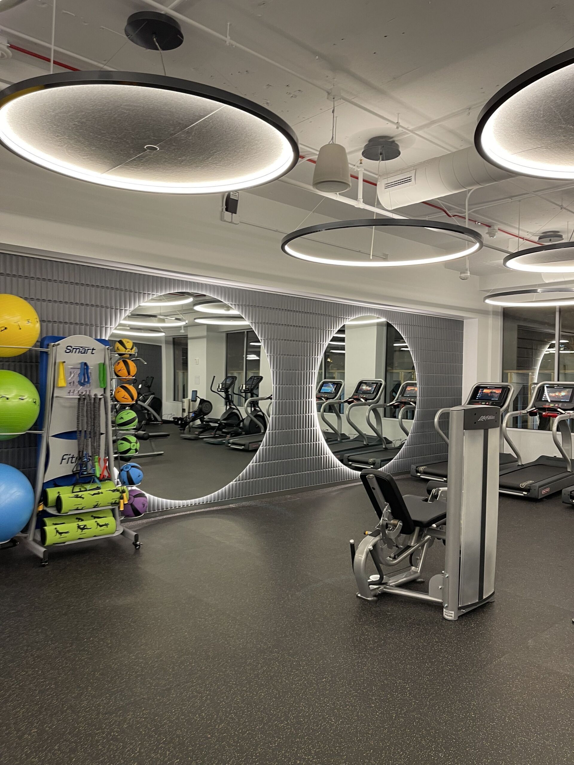 A gym with a lot of mirrors and exercise equipment