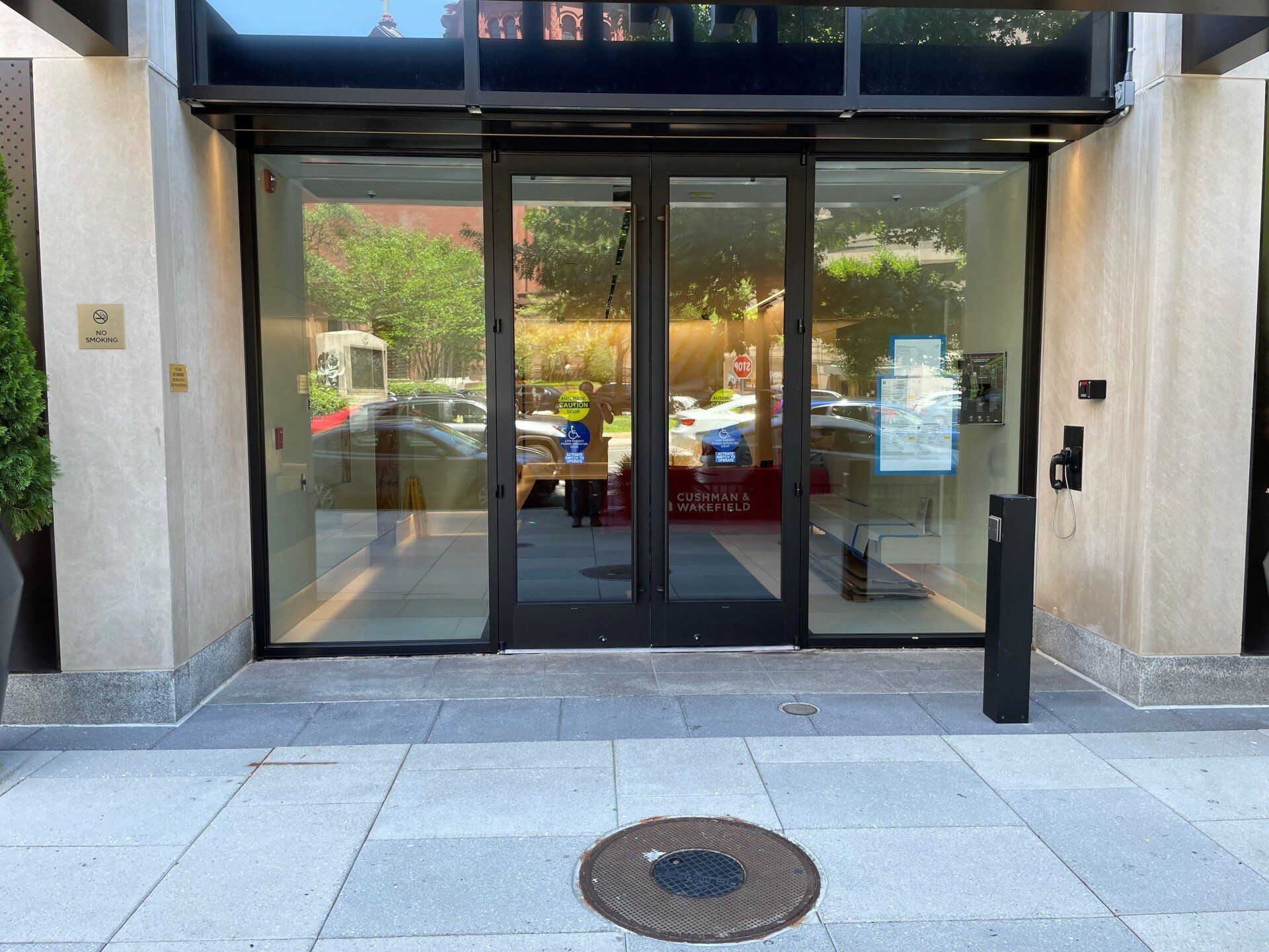 A building with a sliding glass door and a manhole cover