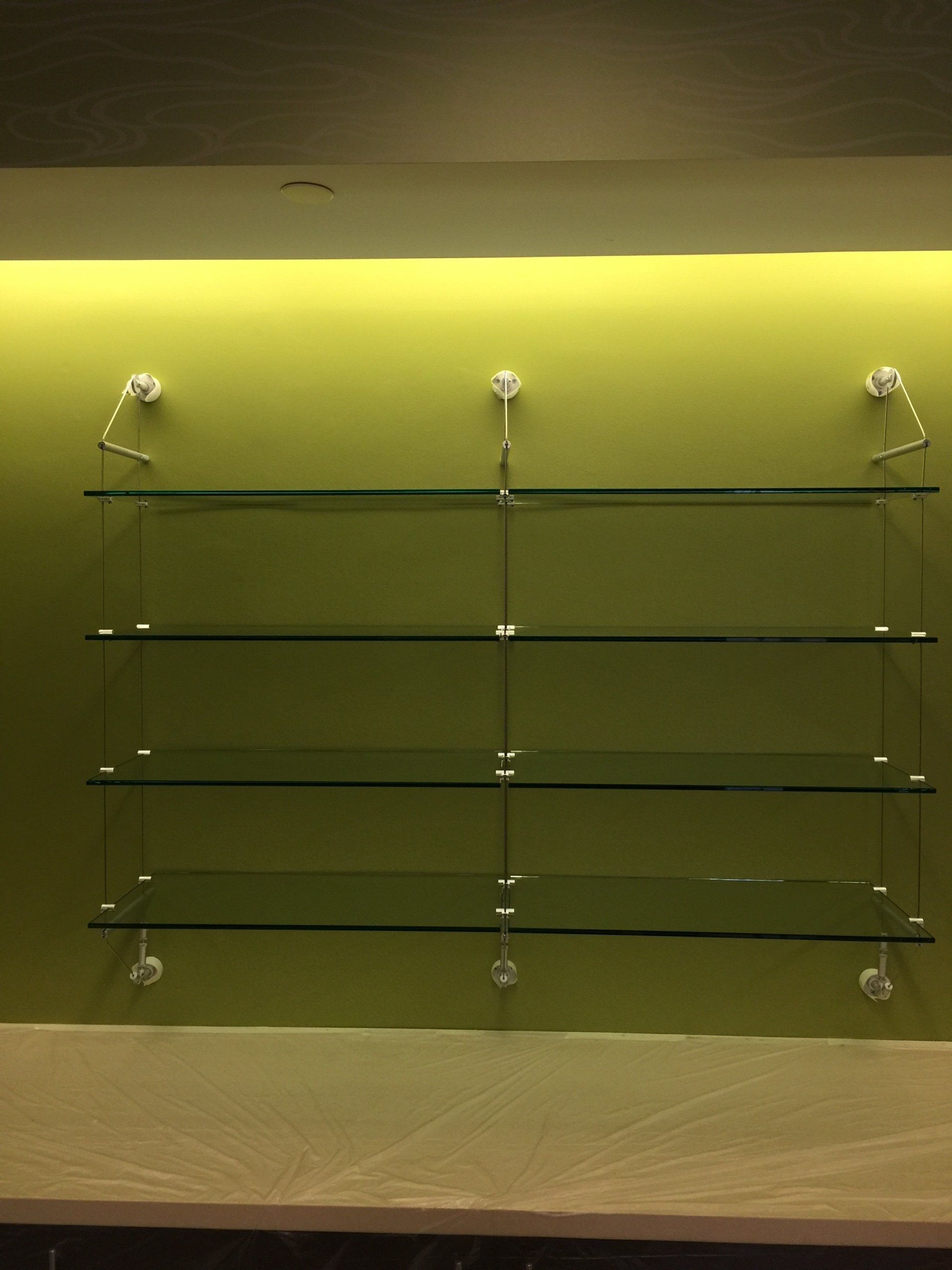 A glass shelf with a green wall behind it