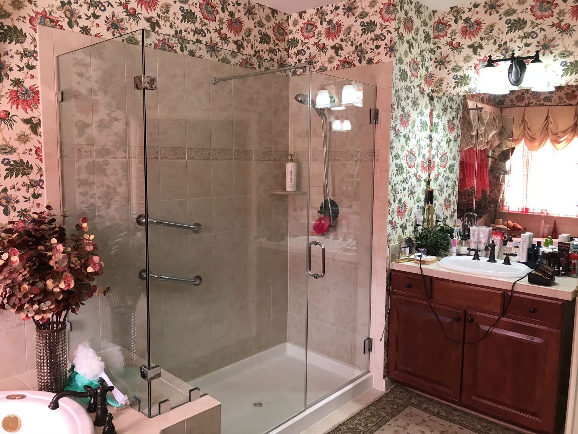 A bathroom with a walk in shower , sink , and mirror.