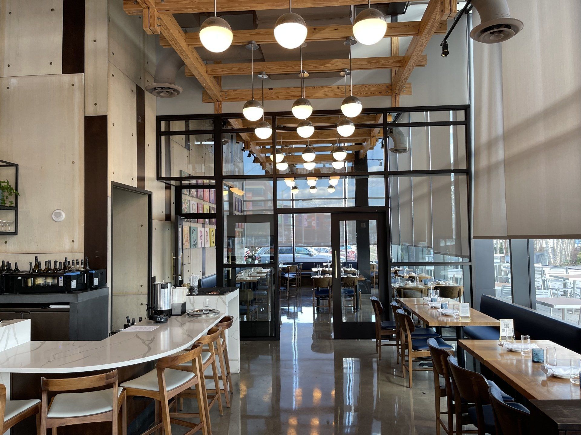 A restaurant with tables and chairs and a large window.