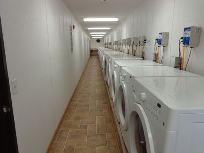 A long hallway filled with washing machines in a laundromat