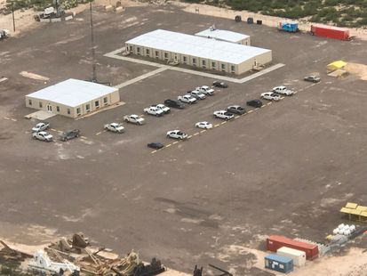An aerial view of a parking lot with cars parked in a row