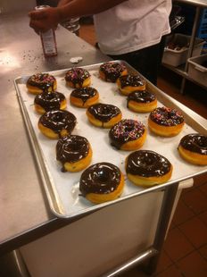 A tray of chocolate covered donuts with sprinkles