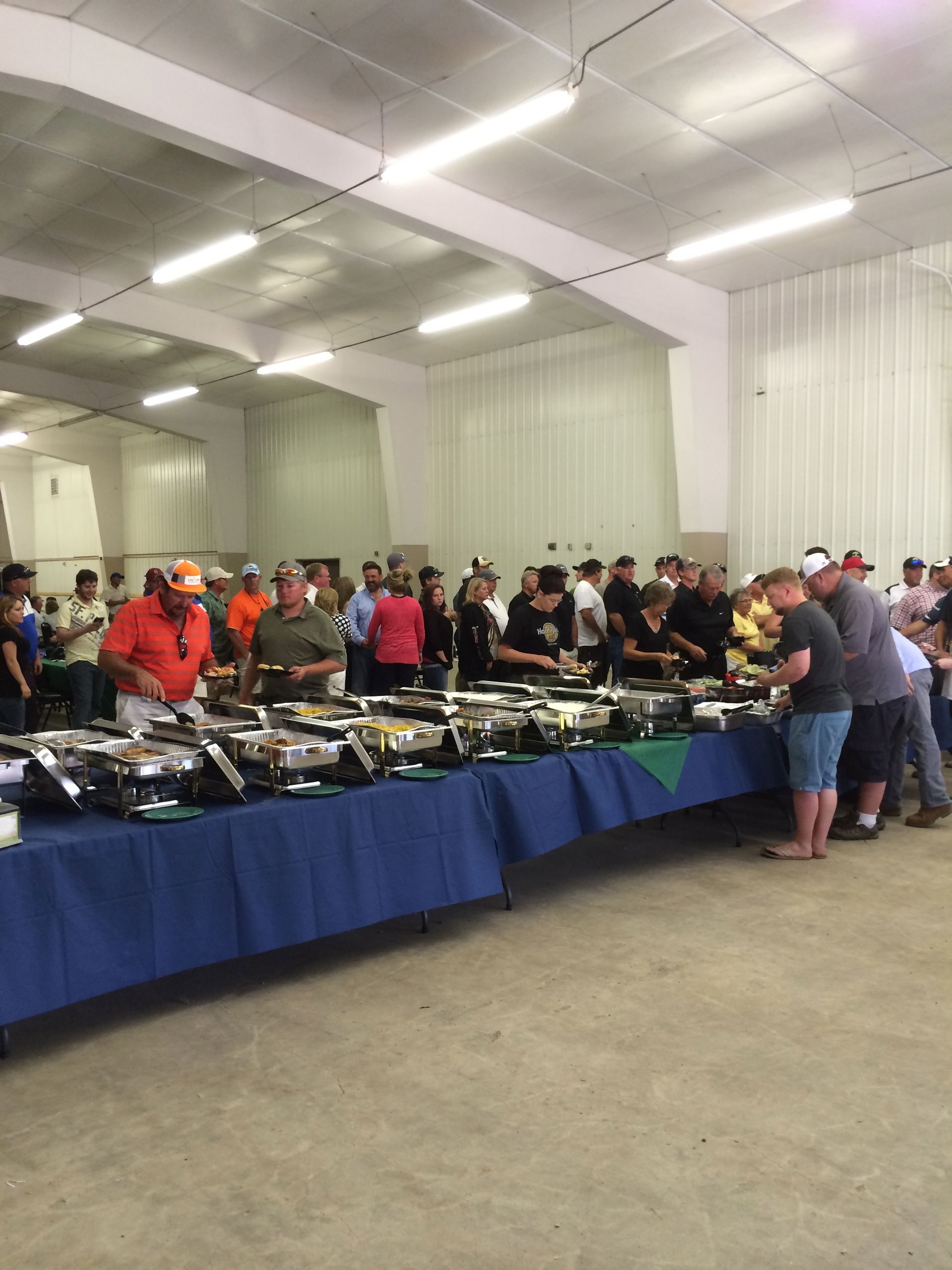 A large group of people are standing around buffet tables