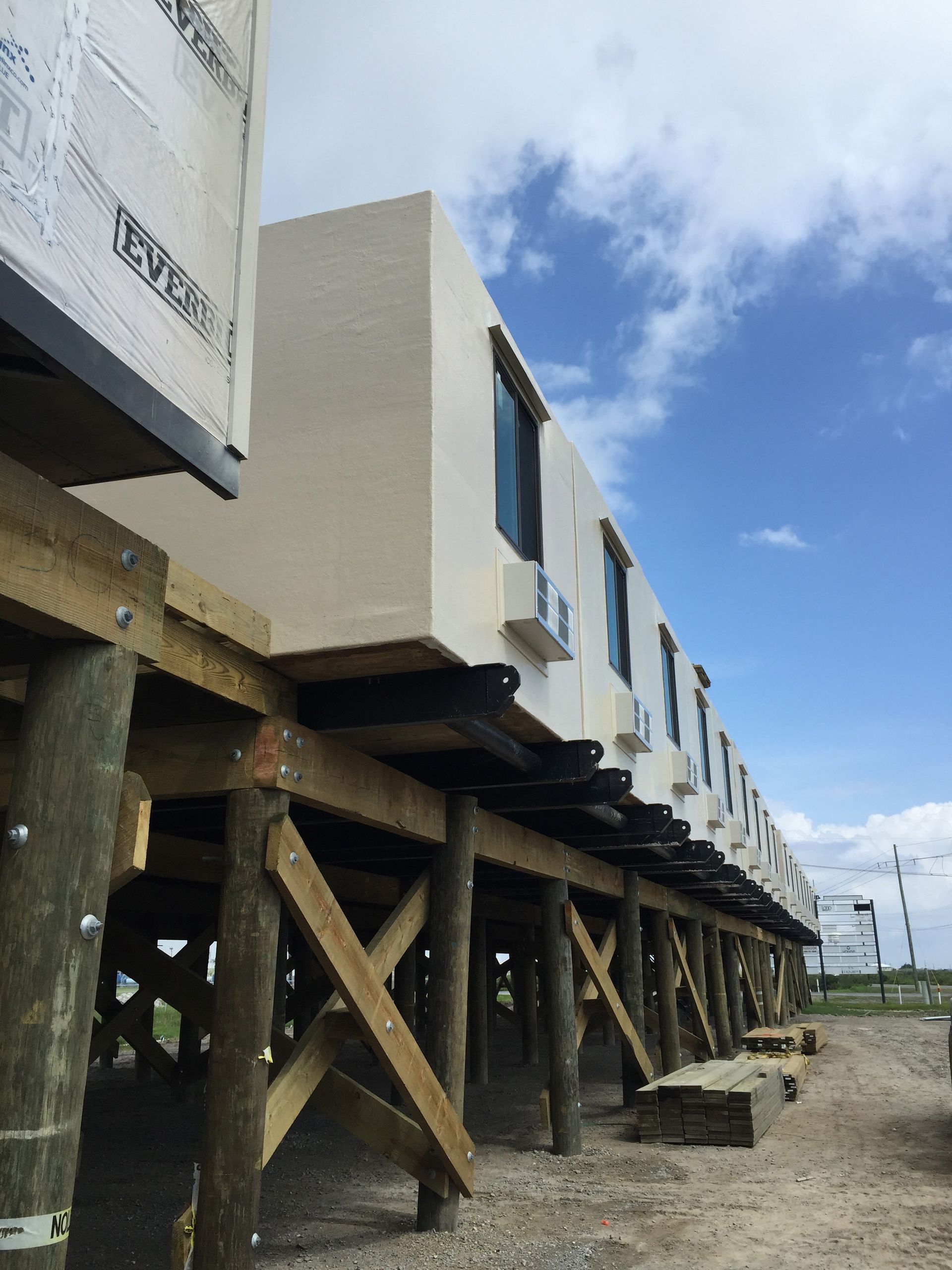 A row of houses are being built on wooden stilts