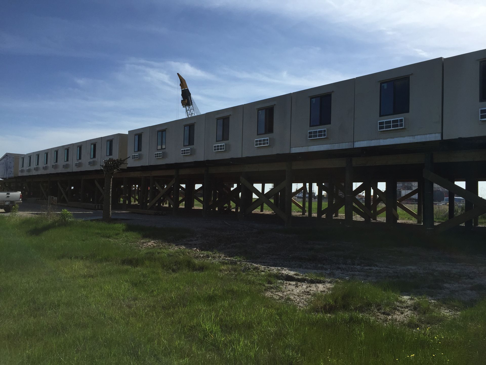 A train is sitting on a bridge over a grassy field