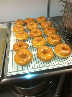 A bunch of glazed donuts on a cooling rack
