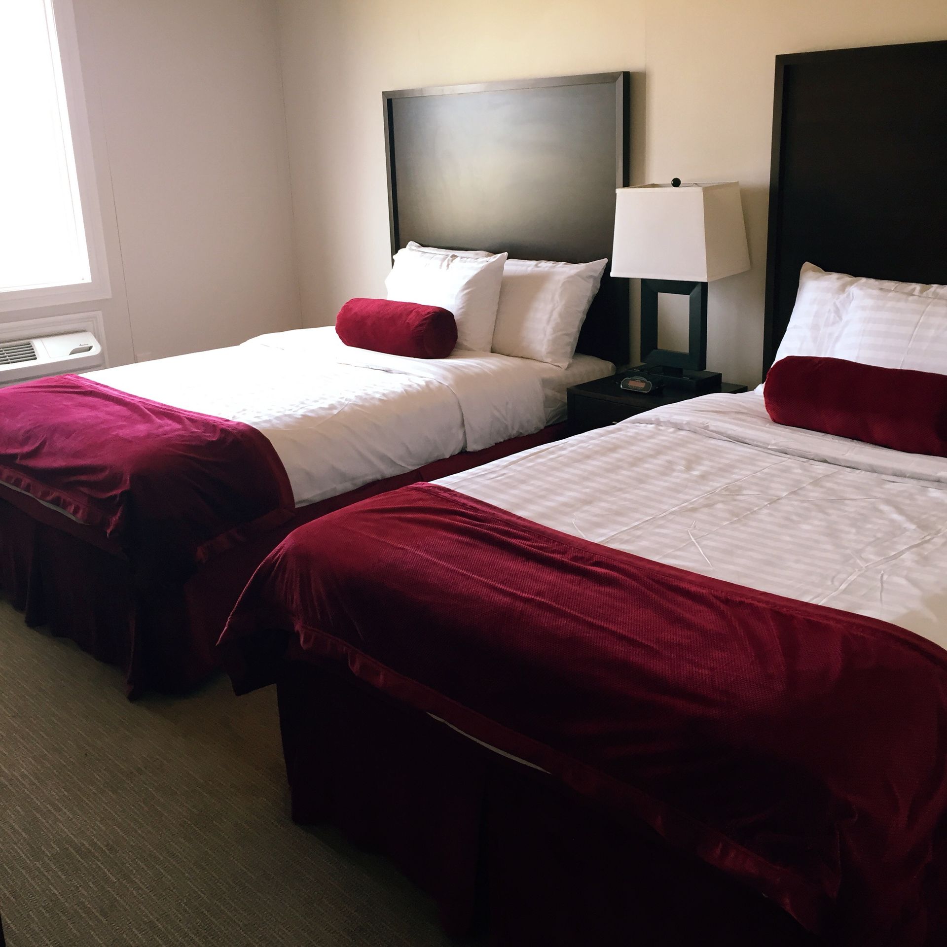 A hotel room with two beds and a lamp