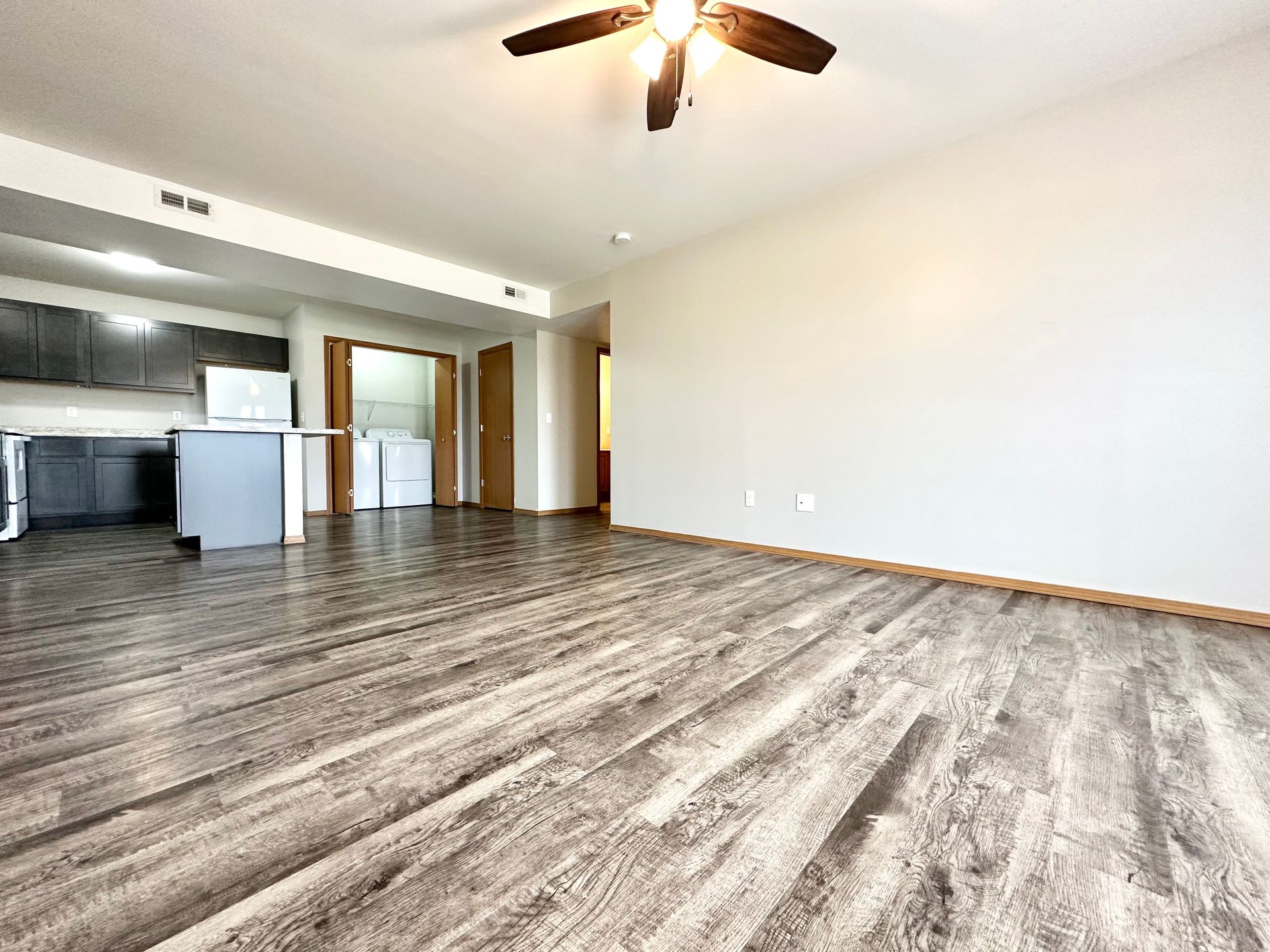 a living room with hardwood floors and a ceiling fan .