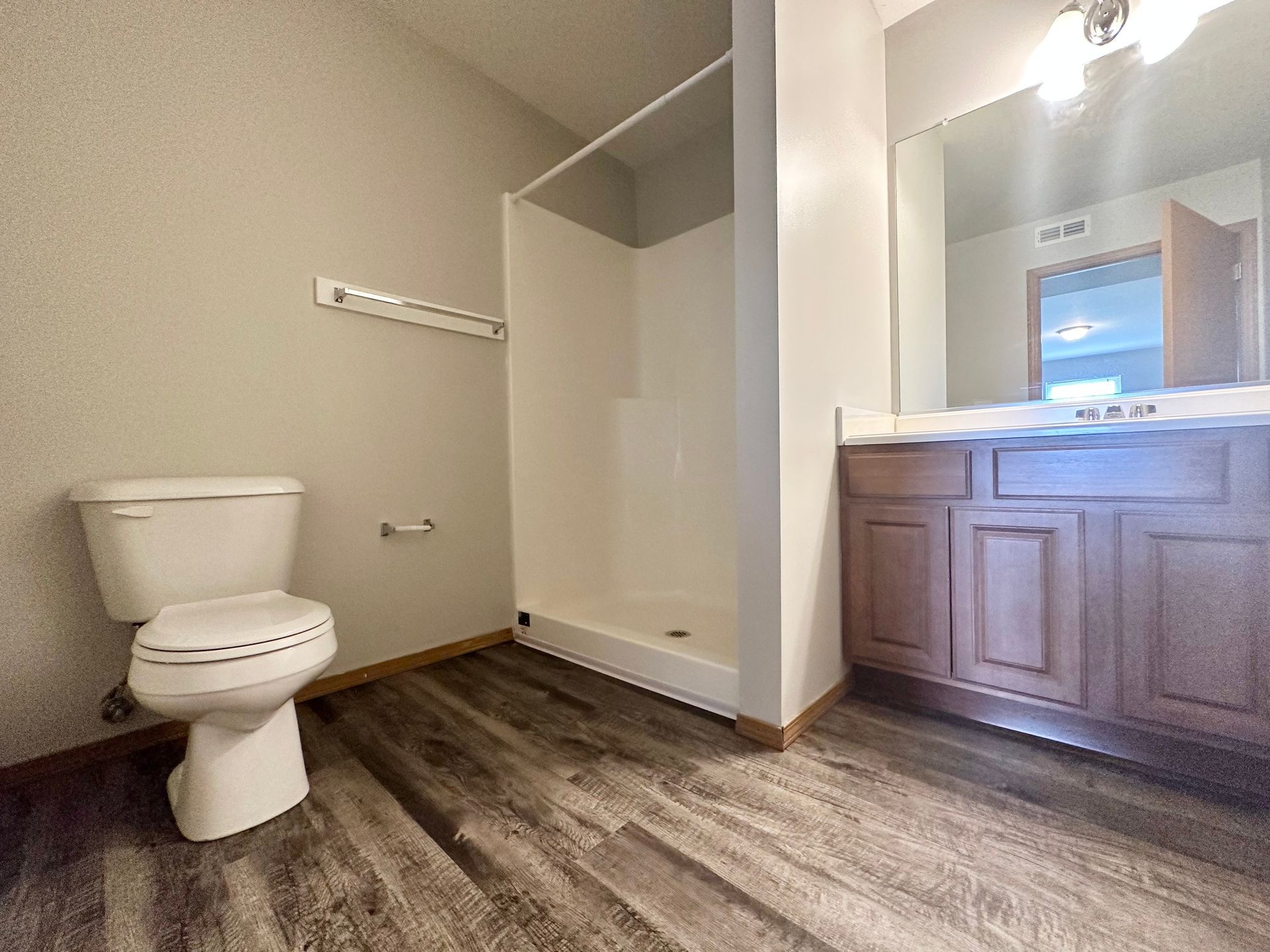 a bathroom with a toilet , sink and shower .