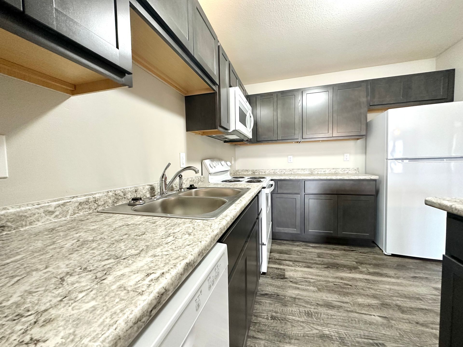 a kitchen with a sink , stove , refrigerator and dishwasher .