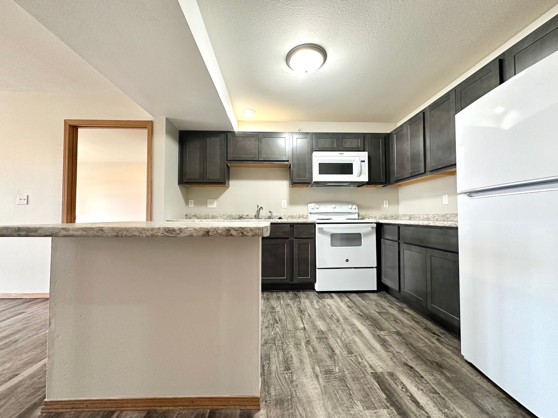a kitchen with a refrigerator , stove , microwave and sink .
