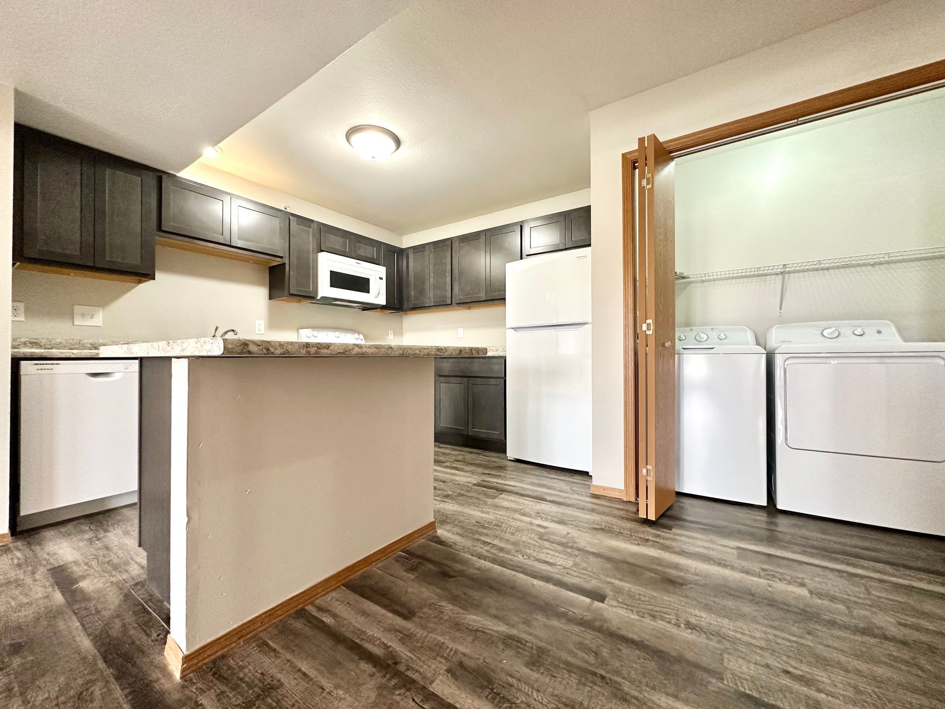 a kitchen with a washer and dryer and a refrigerator .
