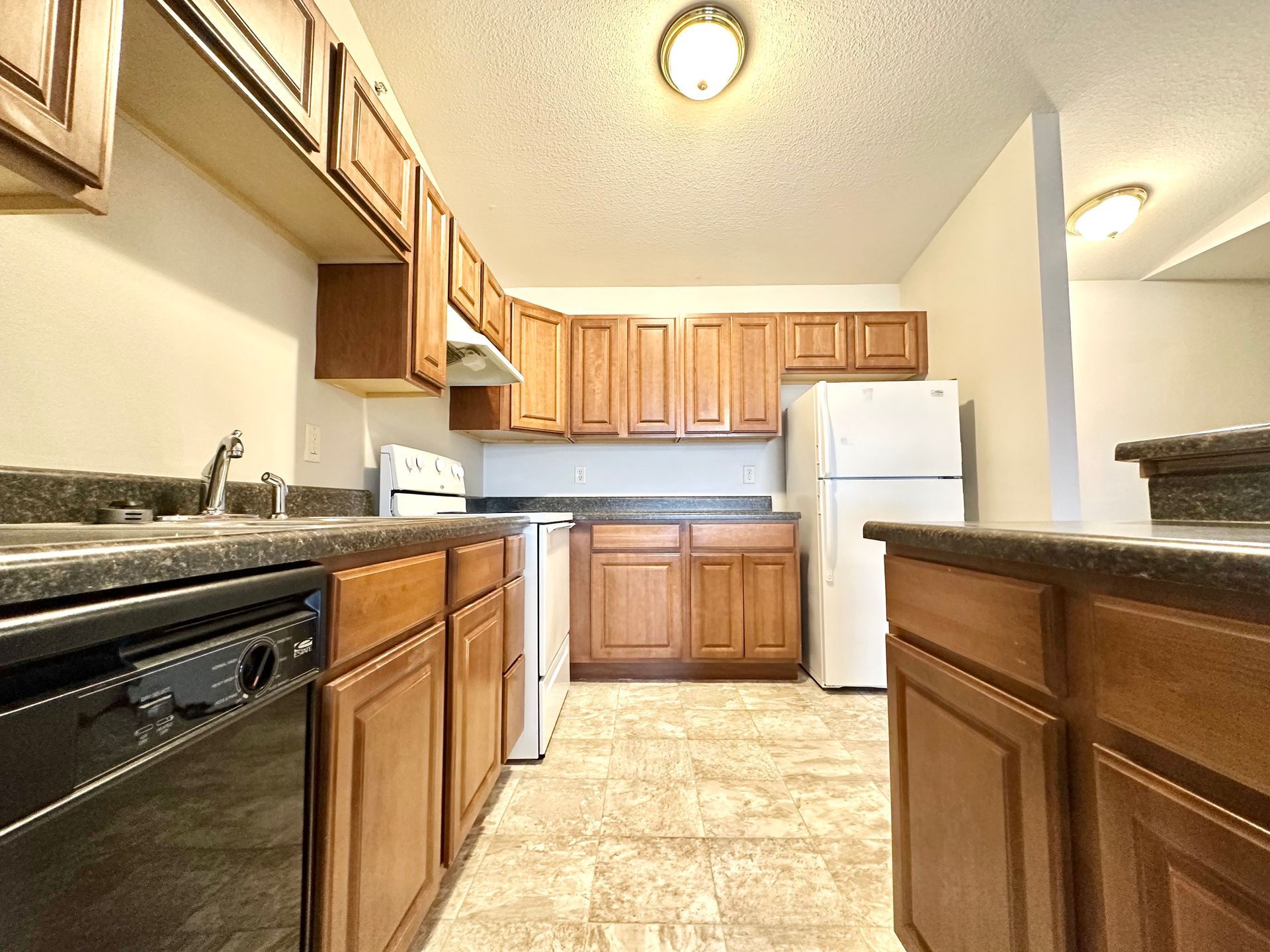 a kitchen with wooden cabinets and a white refrigerator