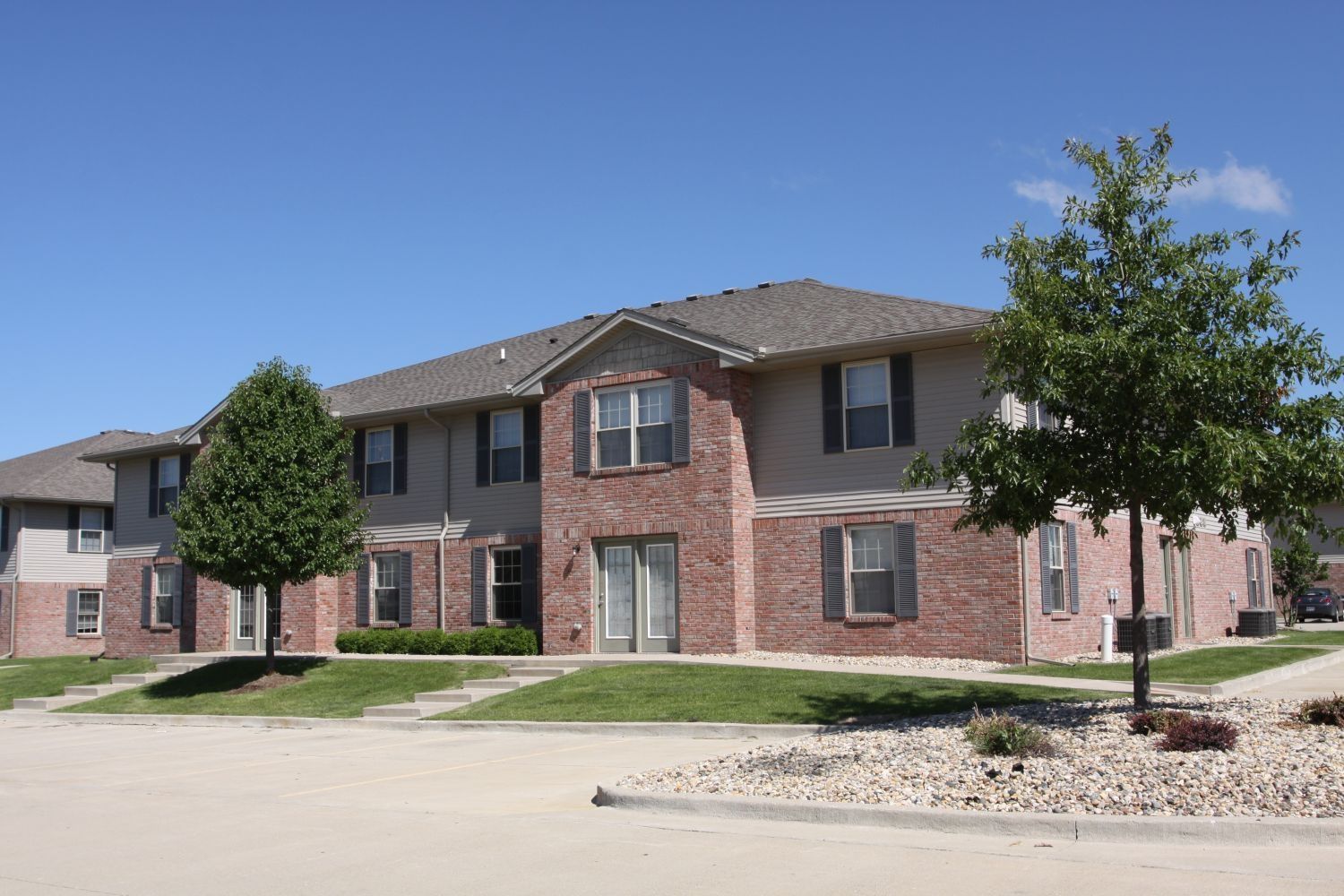 a brick apartment building with a tree in front of it