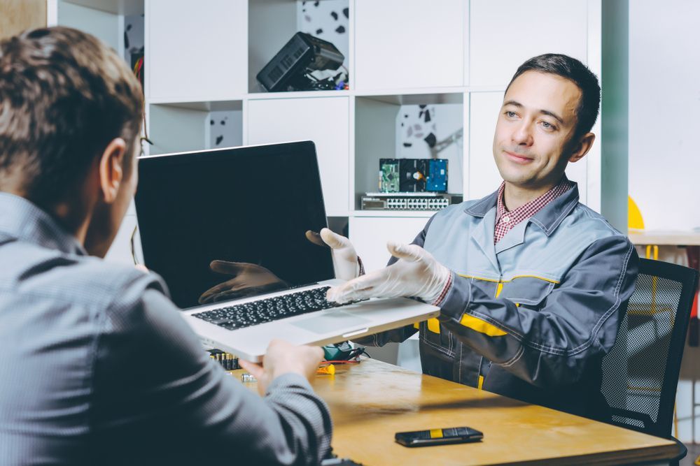 A Man is Fixing a Computer With a Screwdriver — Computers NQ in Aitkenvale, QLD