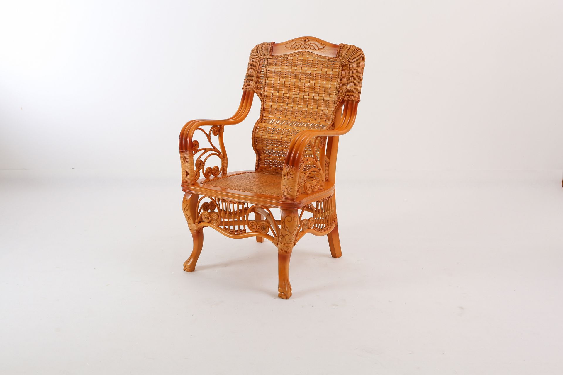 A light brown, ornate wicker armchair with a high back and carved details, centered on a plain white background.