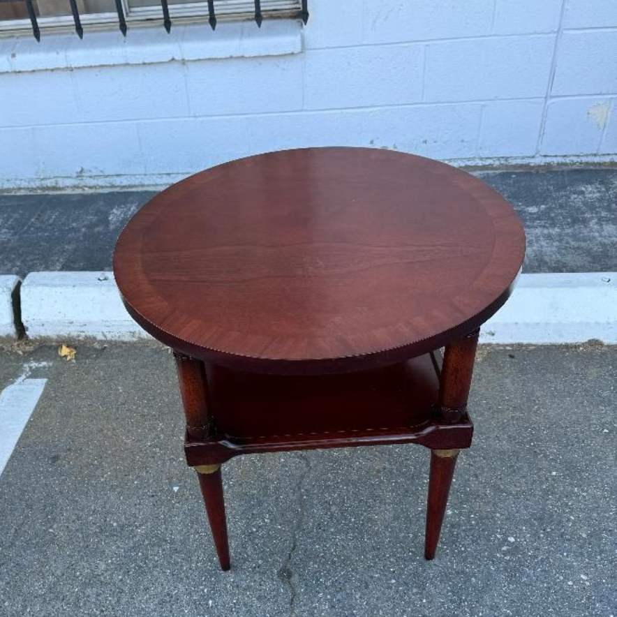 A vintage dark wood roll-top desk with small upper drawers, set in a brightly lit room.