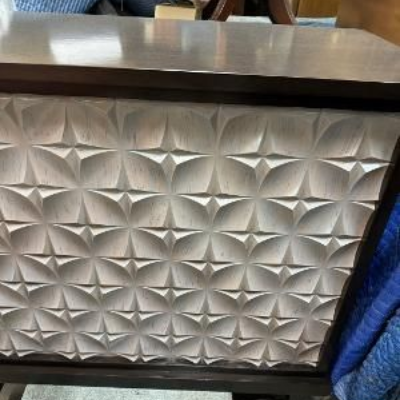 An antique wooden sideboard with a marble top and ornate carvings, featuring a small potted plant in the center.