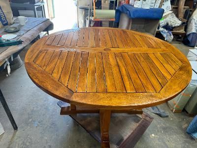 Close-up of polished mahogany wood furniture featuring ornate, carved scrollwork and leaf detailing.