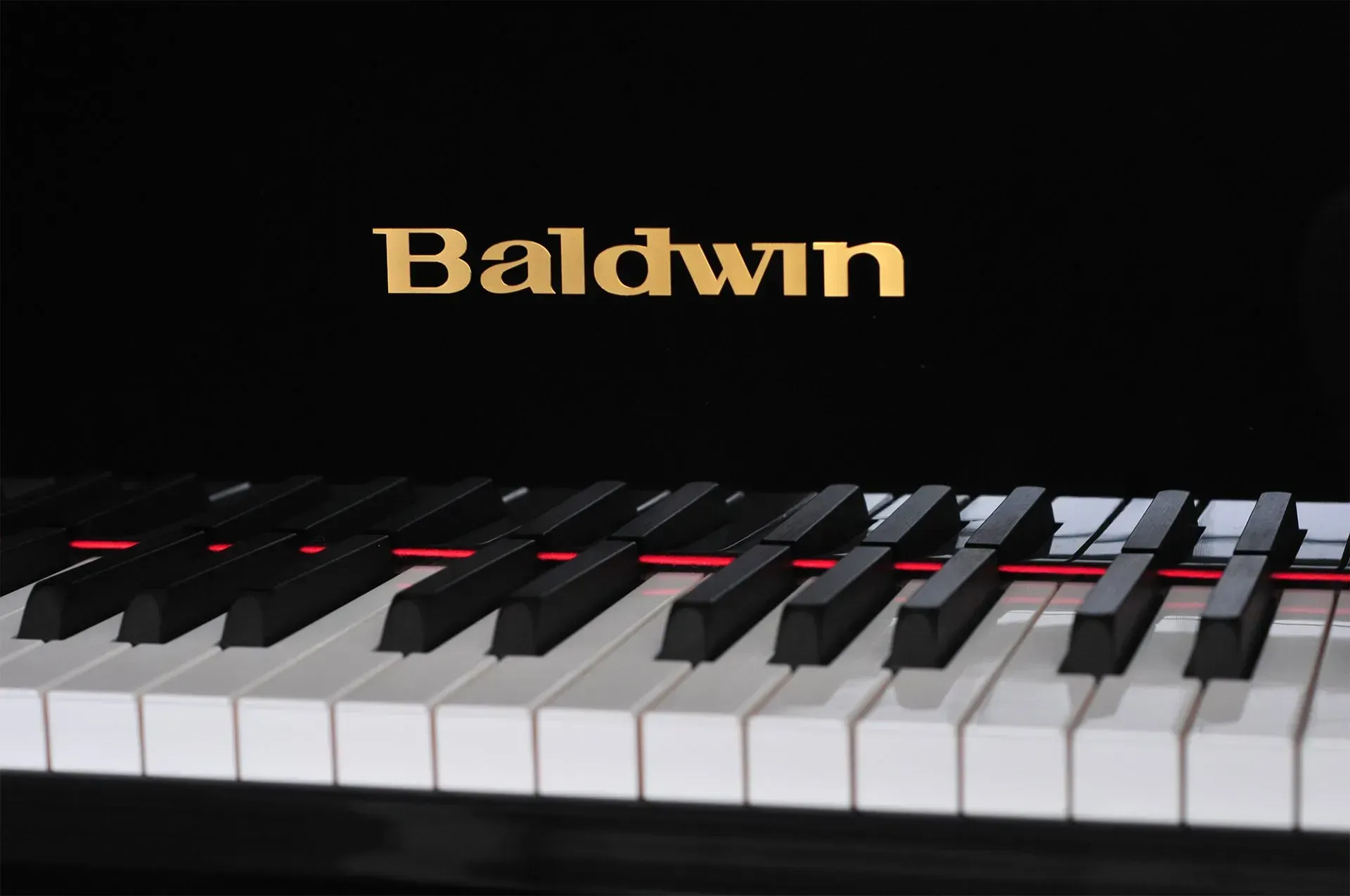A baldwin piano with a black and white keyboard