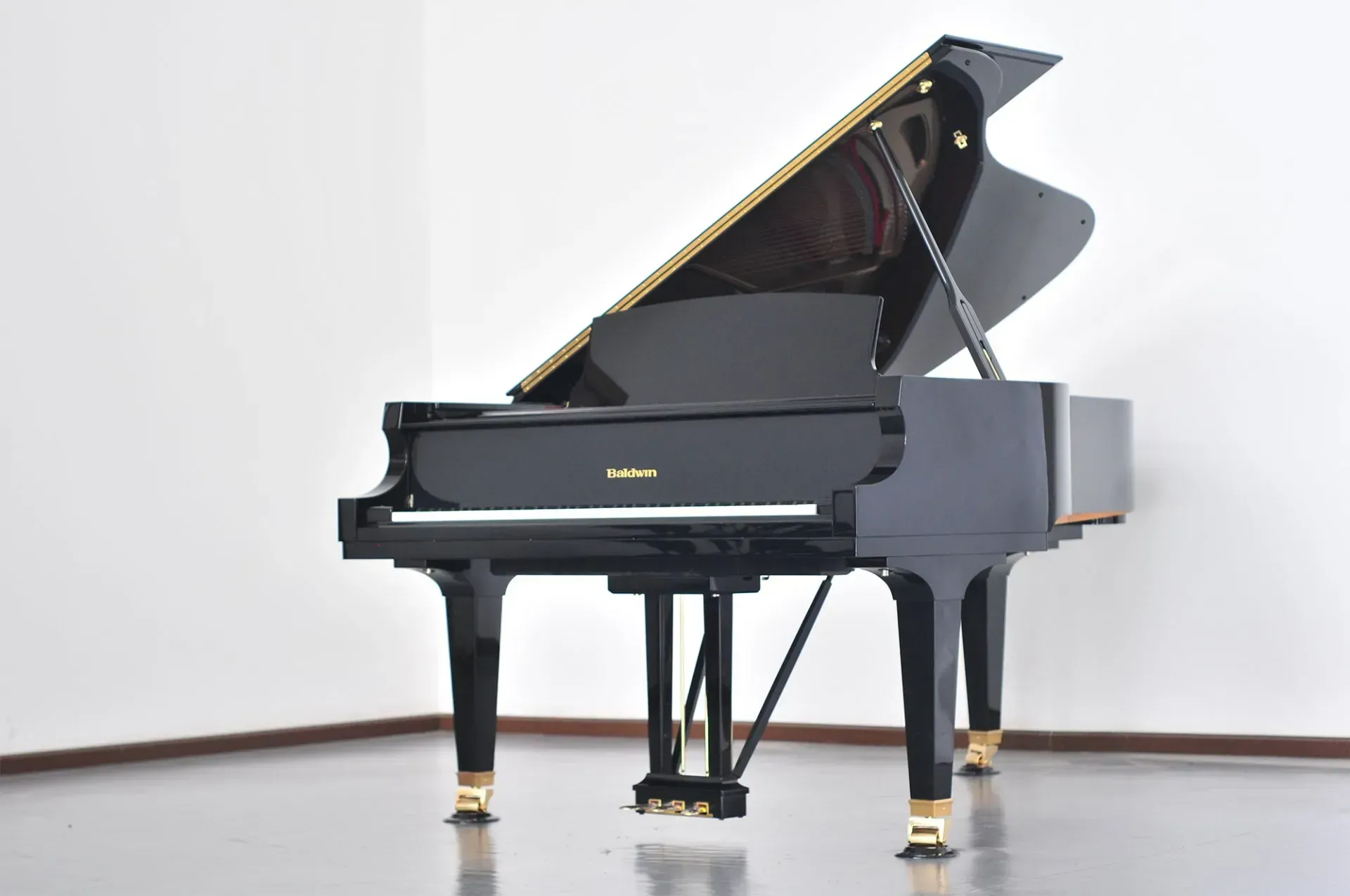 A black grand piano is sitting in a room with the lid open