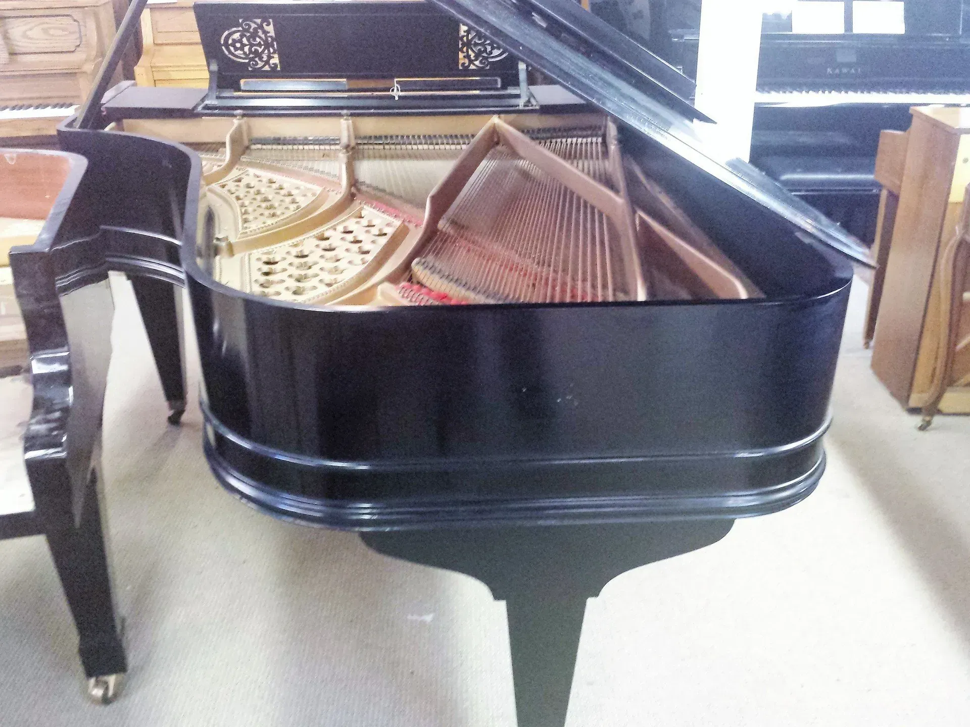 A black grand piano with the lid open in a room