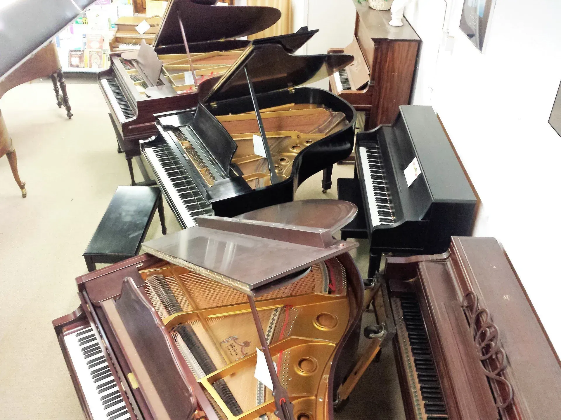 A row of pianos are lined up in a room