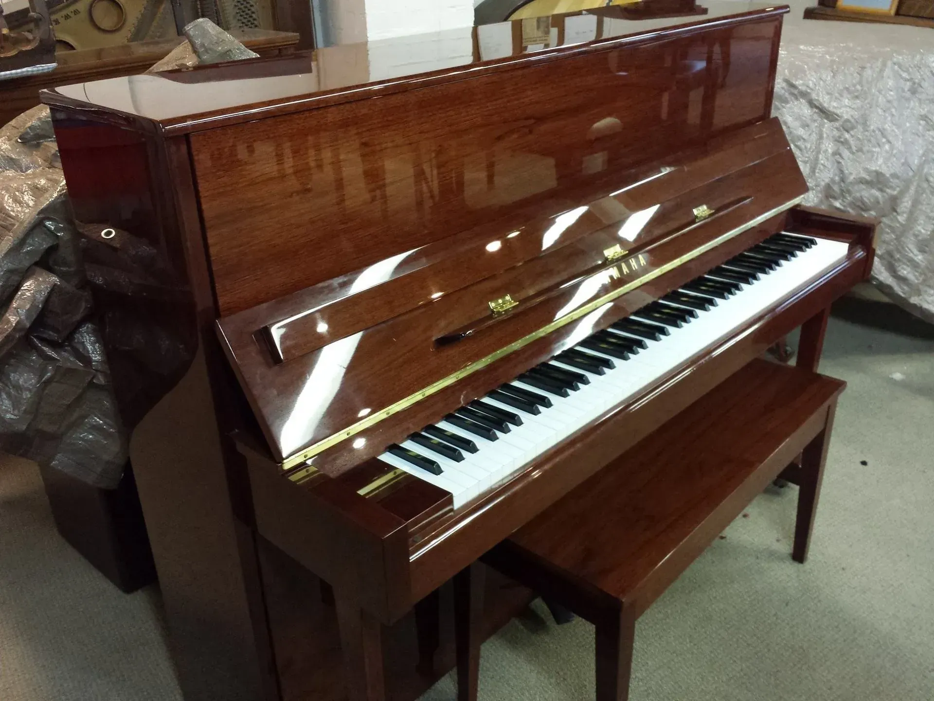 A piano with a bench underneath it in a room