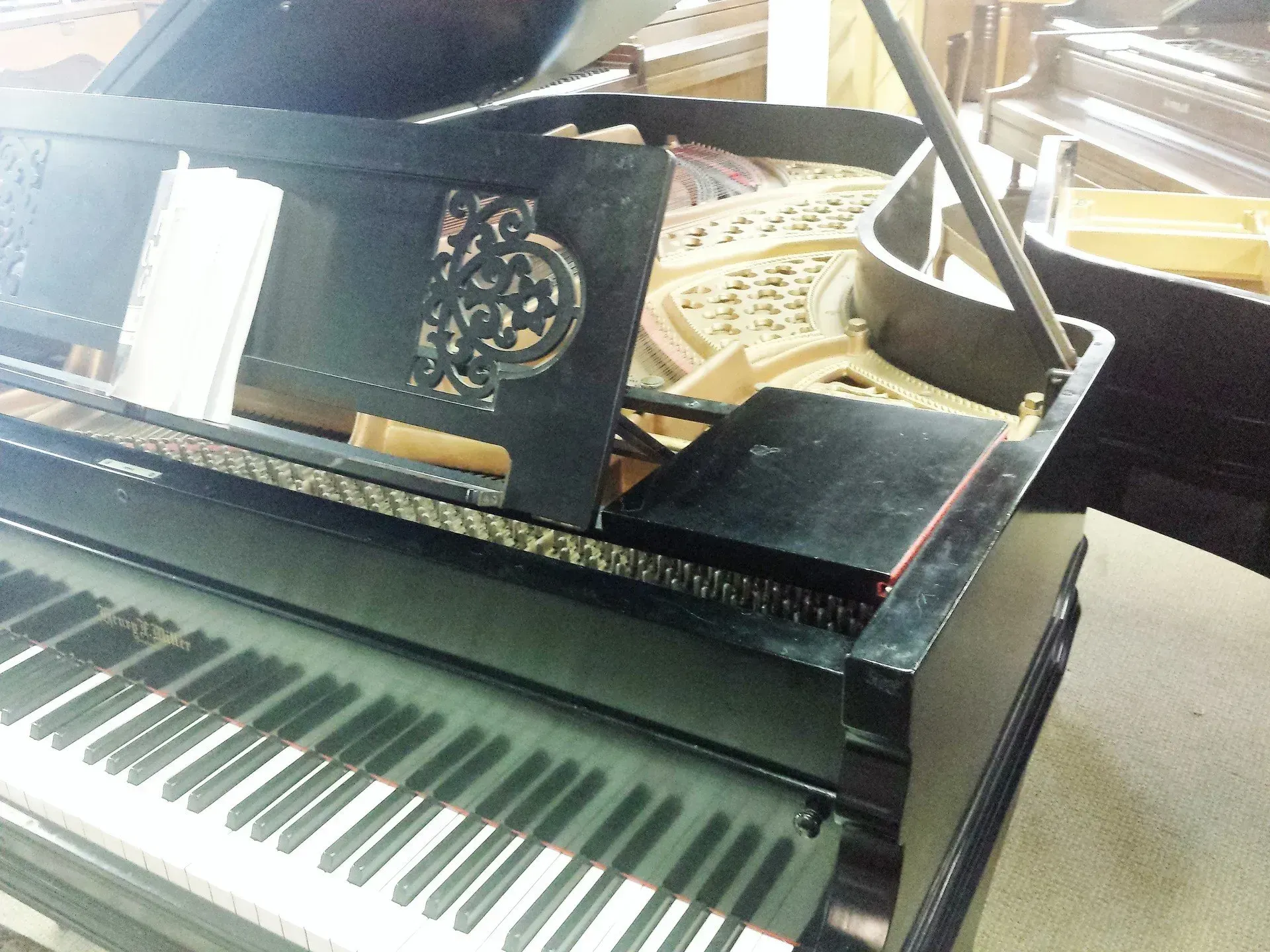 A piano with a broken keyboard is sitting on the floor