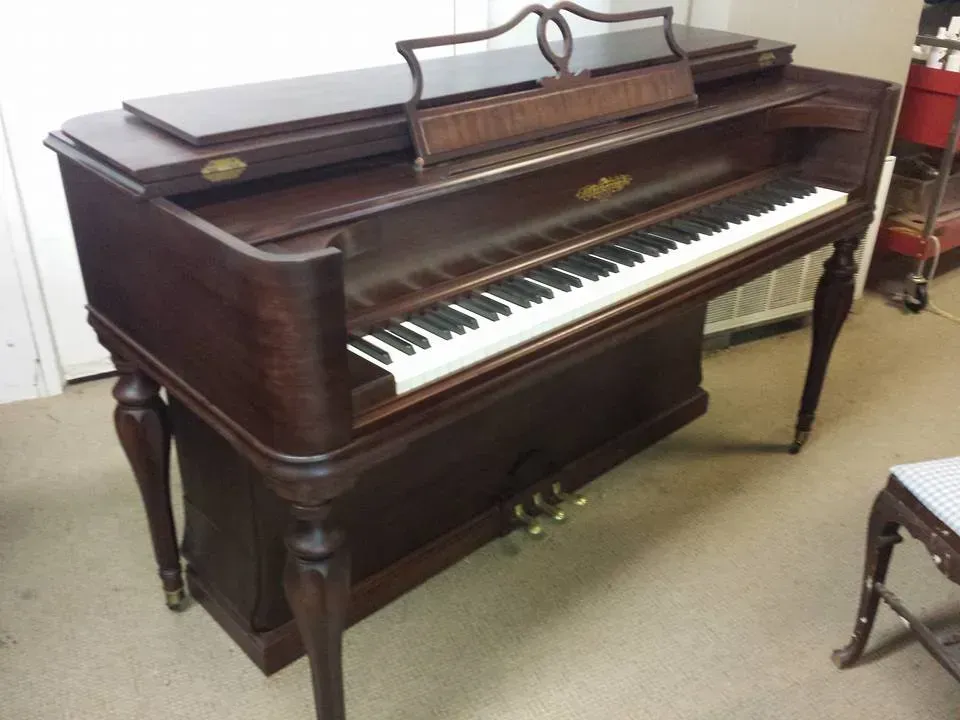 A piano is sitting in a room next to a chair