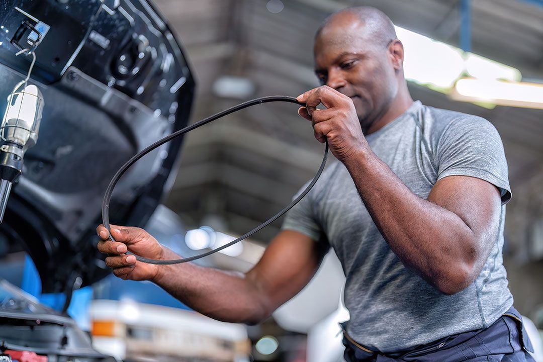 A man is working on a car in a garage.