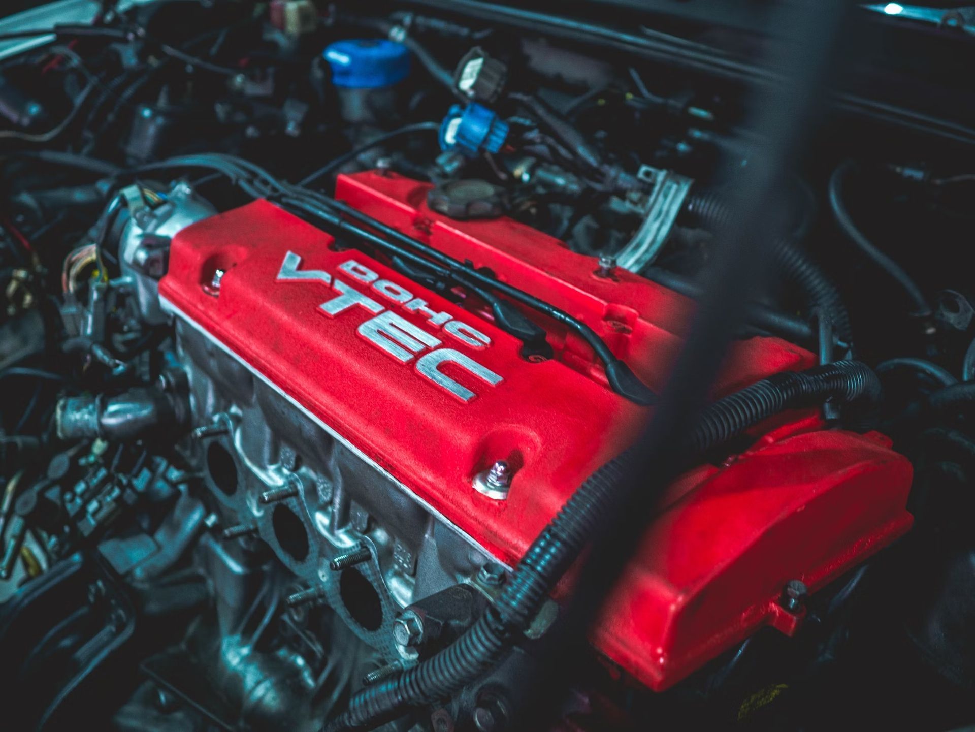 A close up of a red vtec engine in a car.