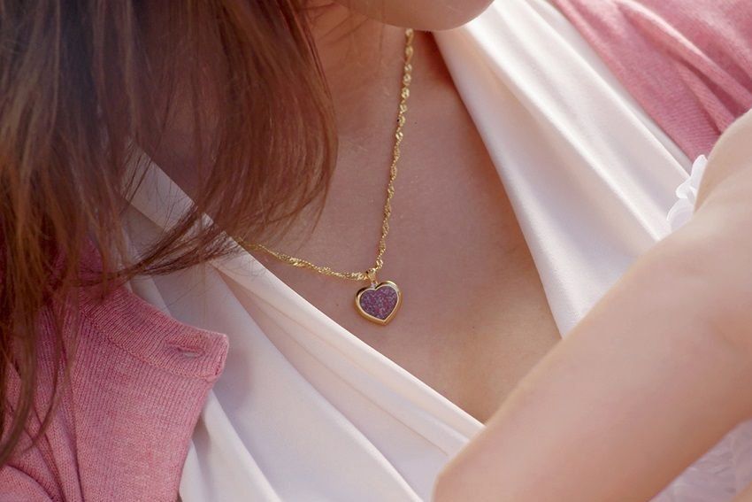 Woman wearing a gold heart necklace