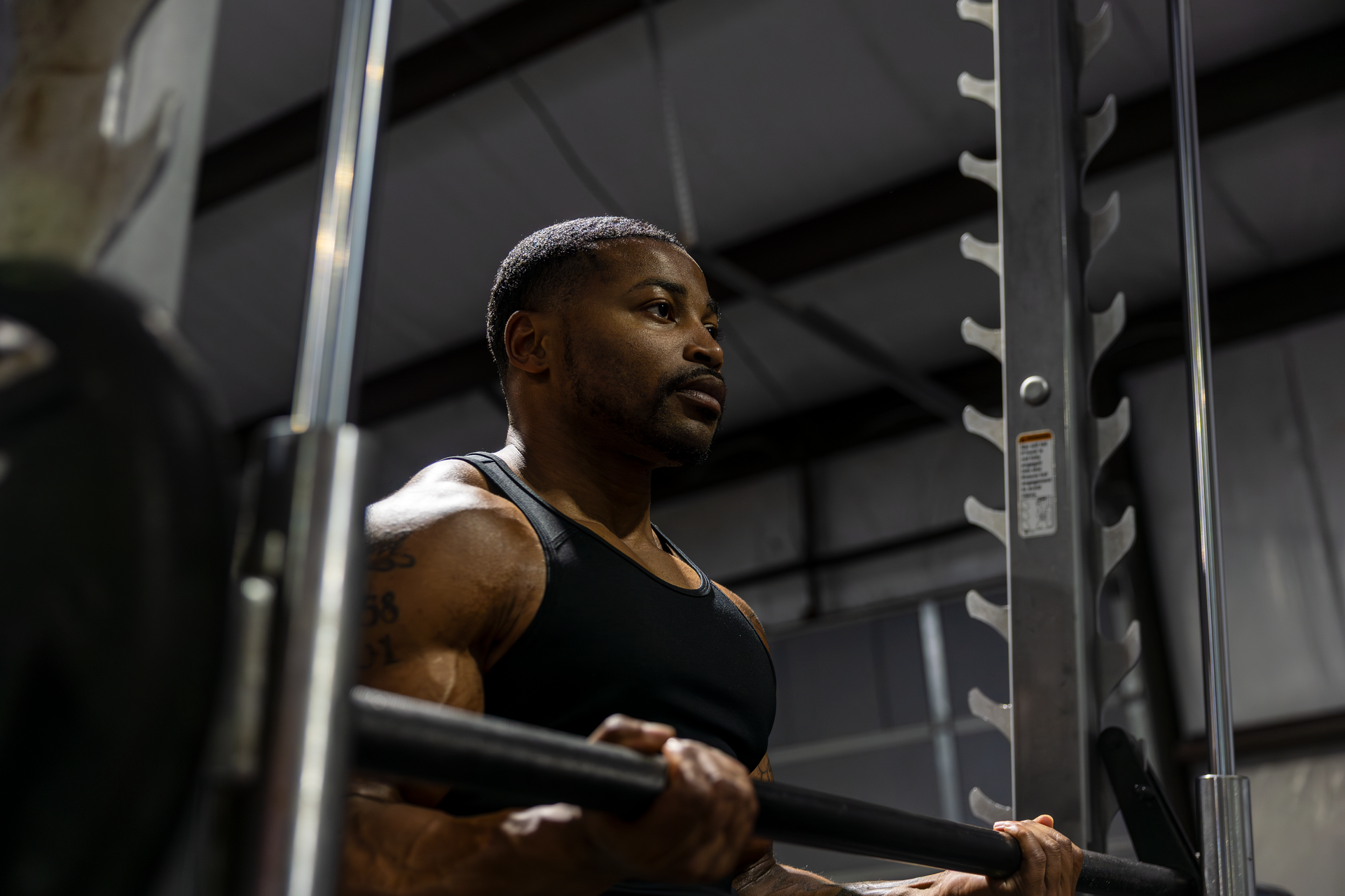 Trey Johnson at 360 image fitness exercising to build strength and working on bicep muscles in all black workout clothes