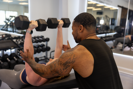 Trainer Trey at 360 Image Fitness gym in Watkinsville, GA helping spot a female with arm strengthening transforming exercises