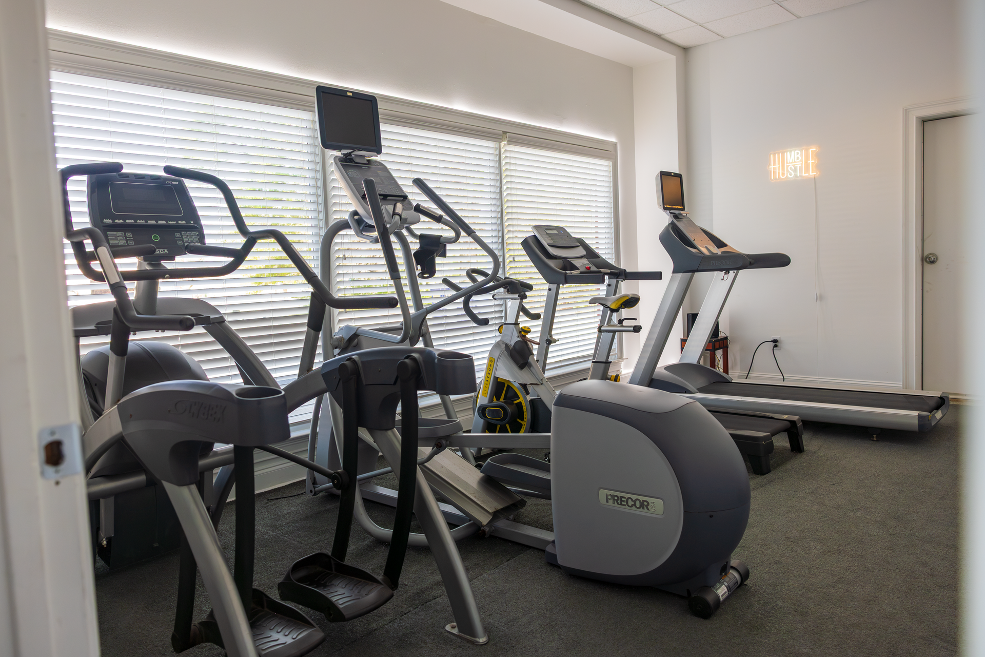Gym room with treadmills, ellipticals, and other cardio equipment by large windows in 360 image fitness gym